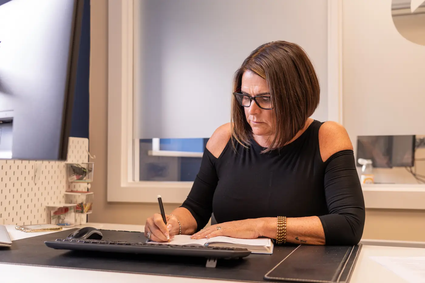 A colleague writing notes at her desk
