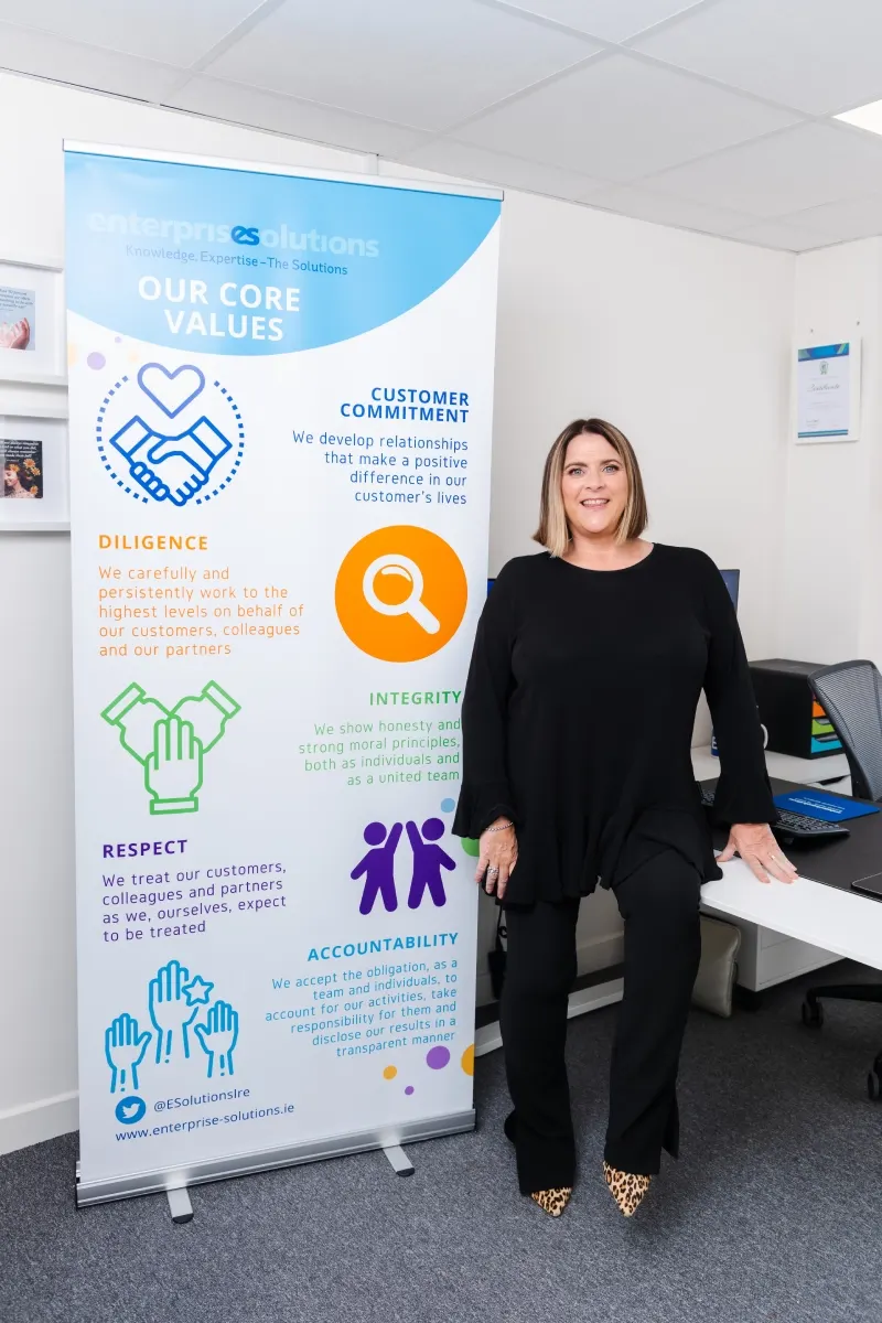 Denise Cullen, Managing Director, beside the Enterprise Solutions core values banner