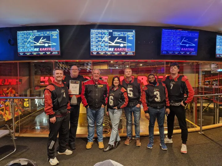 The team in racing suits at the go-karting track